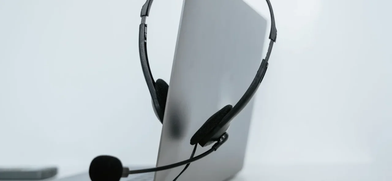 Ordinateur portable avec un casque audio posé sur un bureau, pour suivre un cours de langue en visio