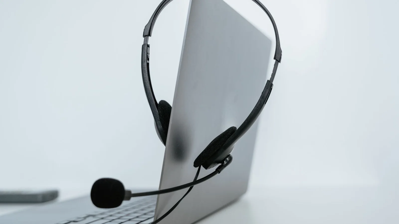 Ordinateur portable avec un casque audio posé sur un bureau, pour suivre un cours de langue en visio